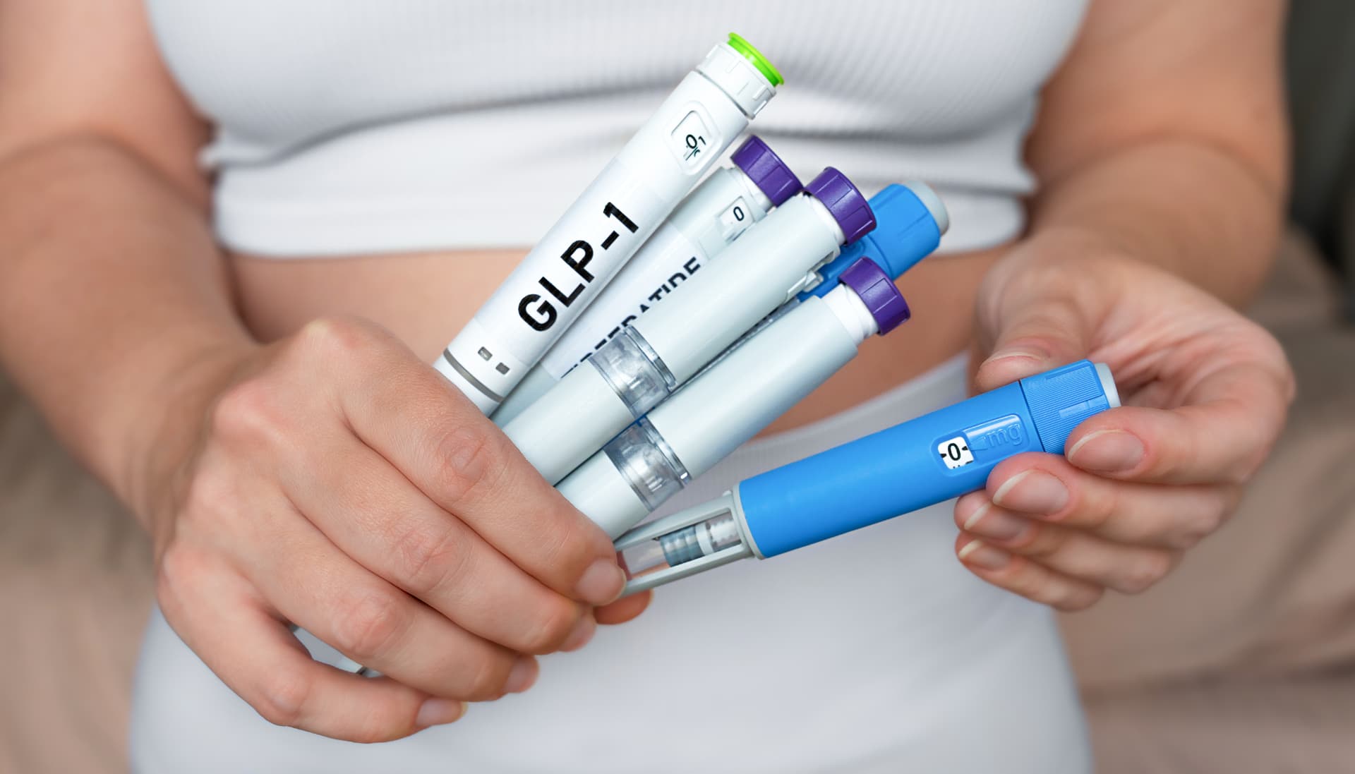 Woman holding GLP-1 injection pens for physician-supervised medical weight loss in Napa